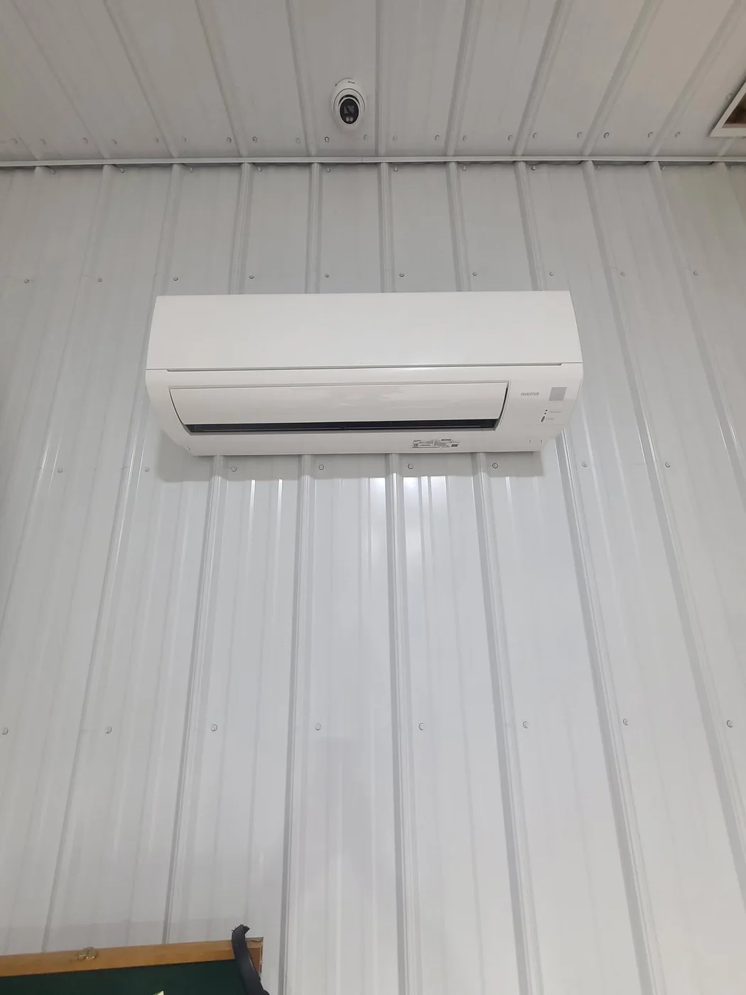 Mitsubishi ductless mini-split indoor wall head mounted on a white metal wall